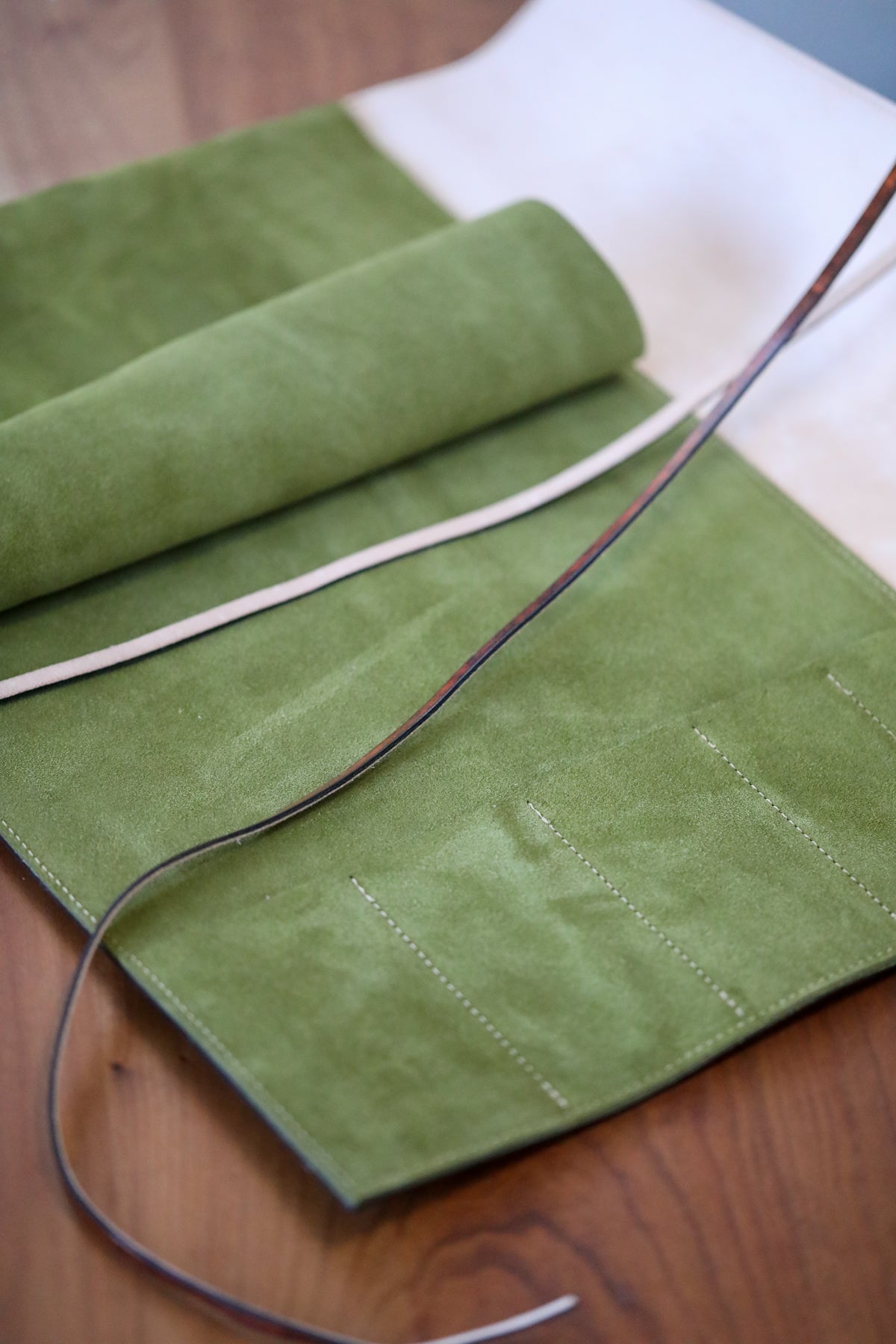brown leather knife roll with green interior