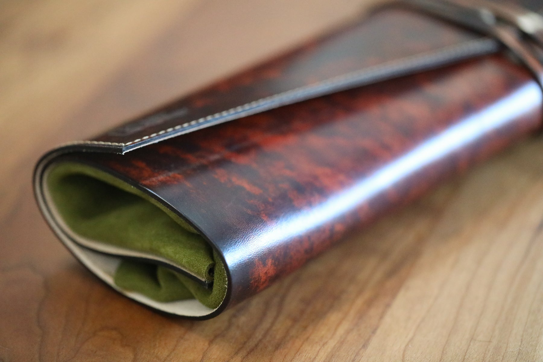 brown leather knife roll with green interior