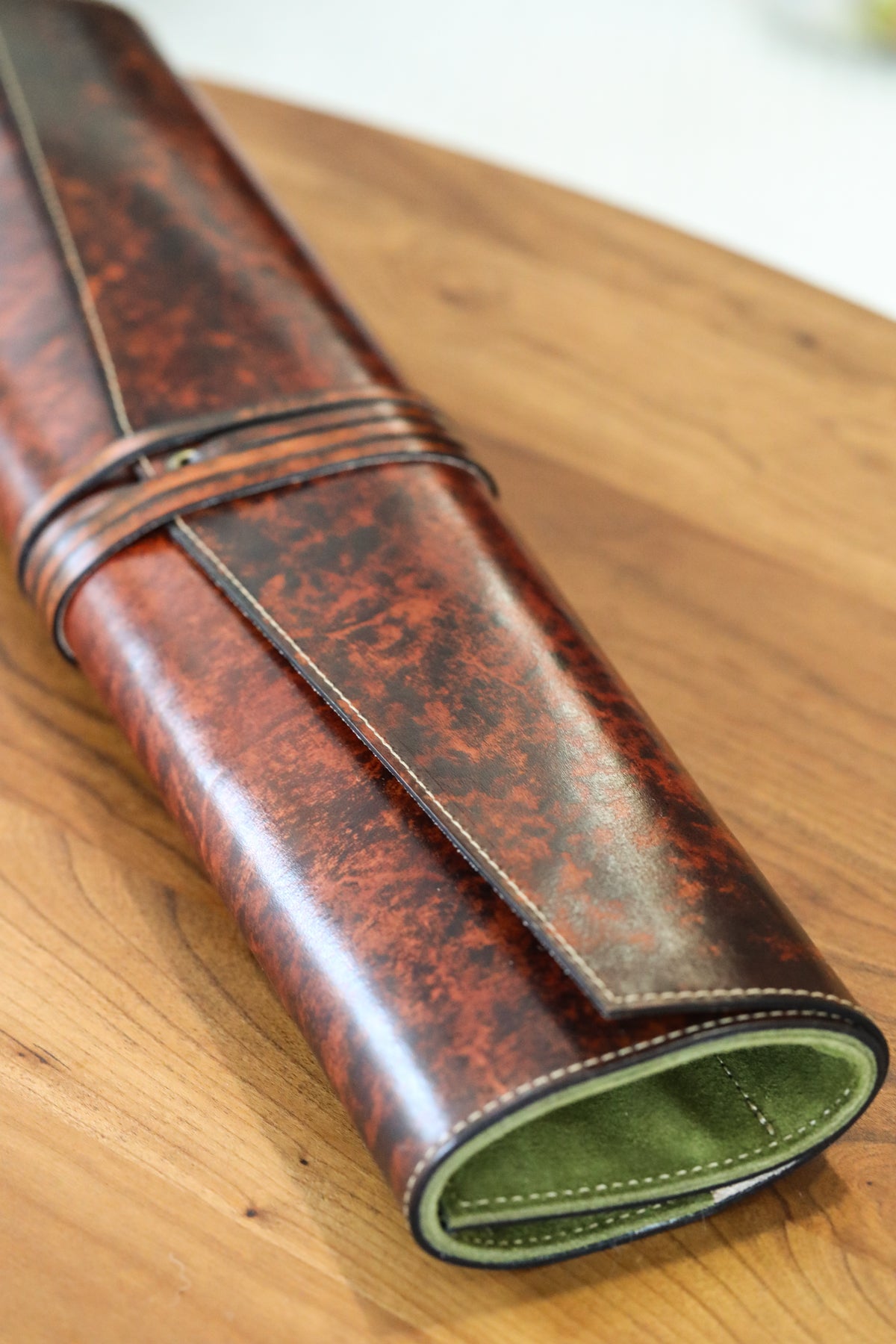 brown leather knife roll with green interior